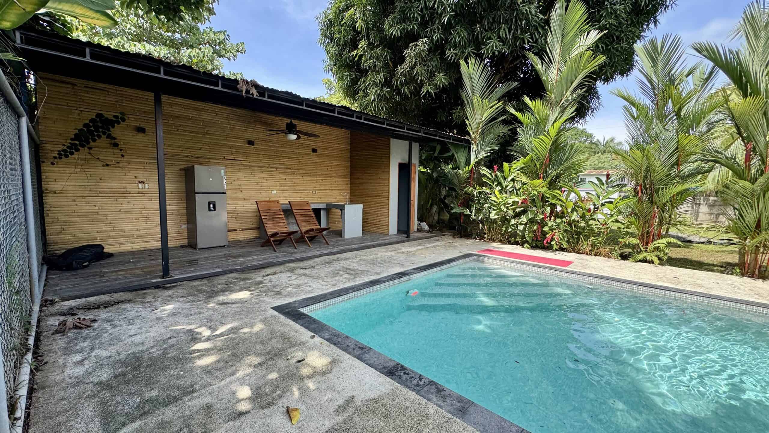 Covered outdoor terrace with ceiling fan beside the pool