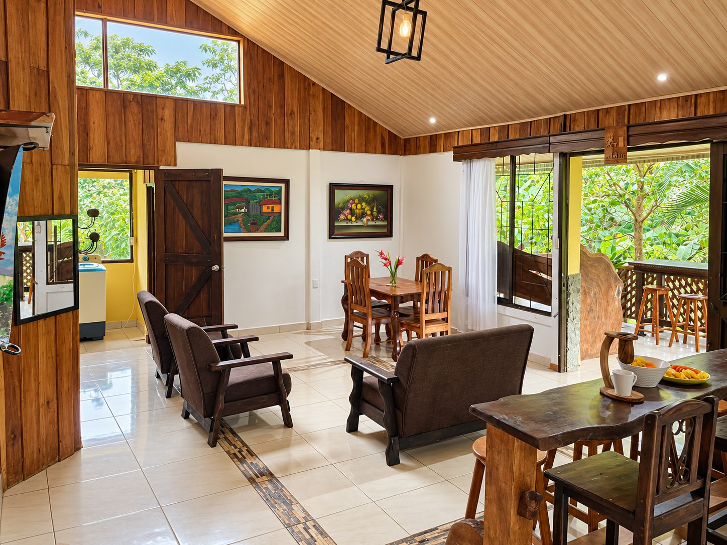 Open-plan living and dining room with a high wooden ceiling and covered terrace