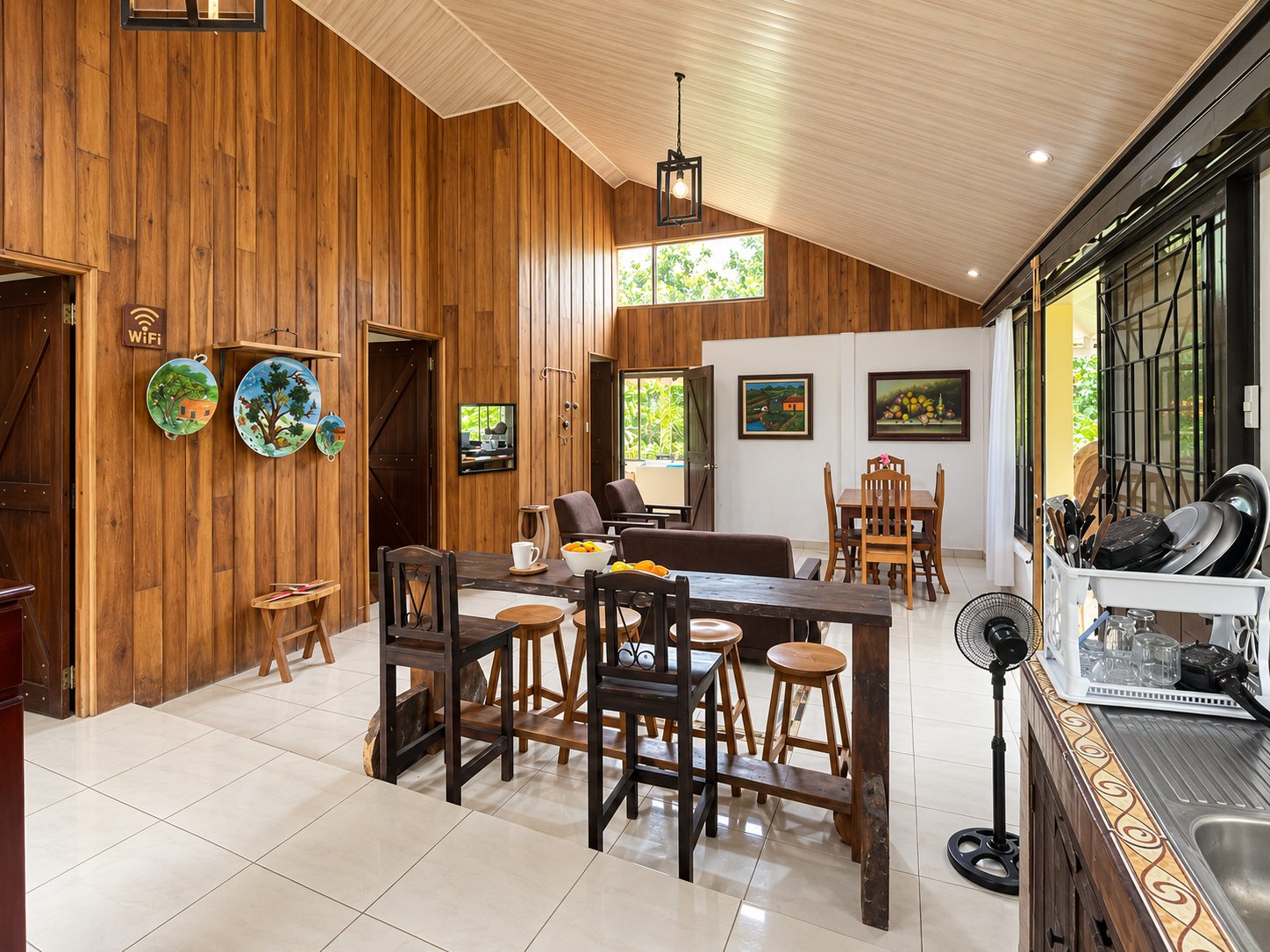 Wood-panelled open-plan living area with breakfast bar and dining table