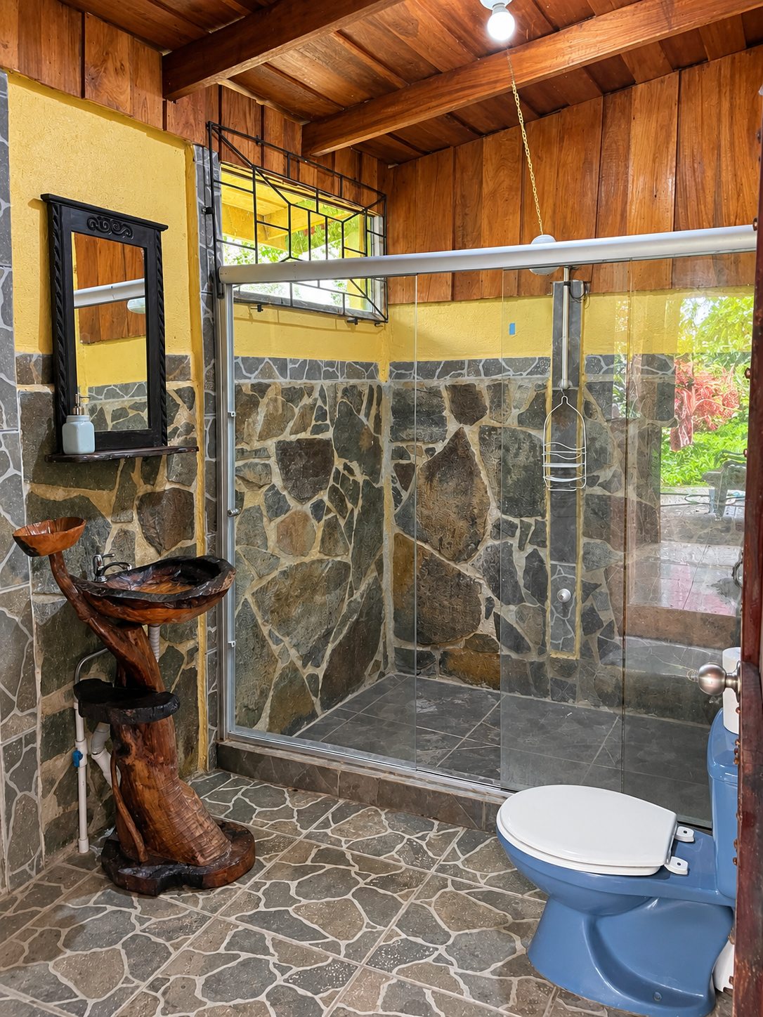 Bathroom with a large stone walk-in shower and a hand-carved wooden sink