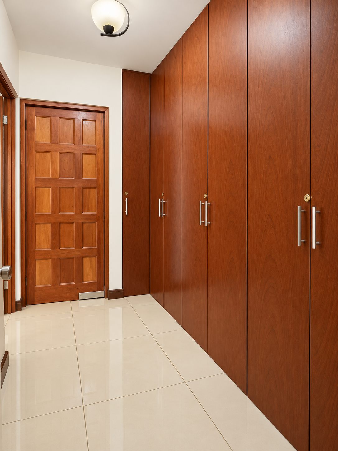Hallway with a wall of built-in wooden wardrobes