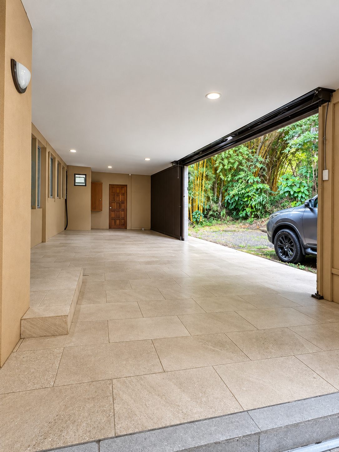 Covered garage entrance with a car parked outside