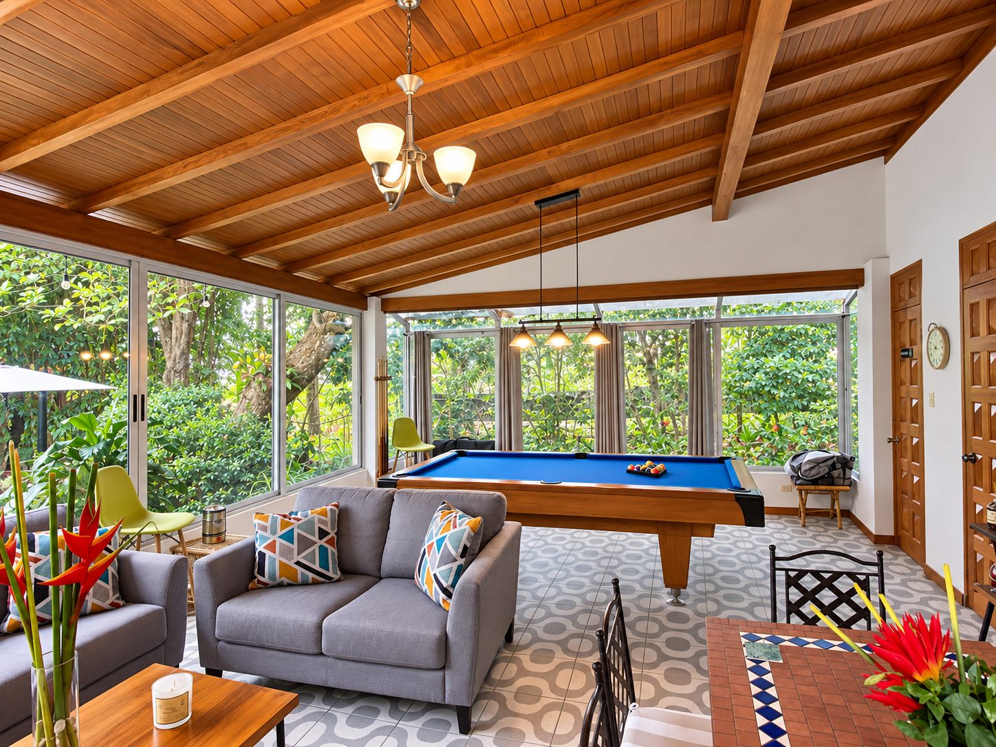 Glass-walled garden room with sofas and pool table