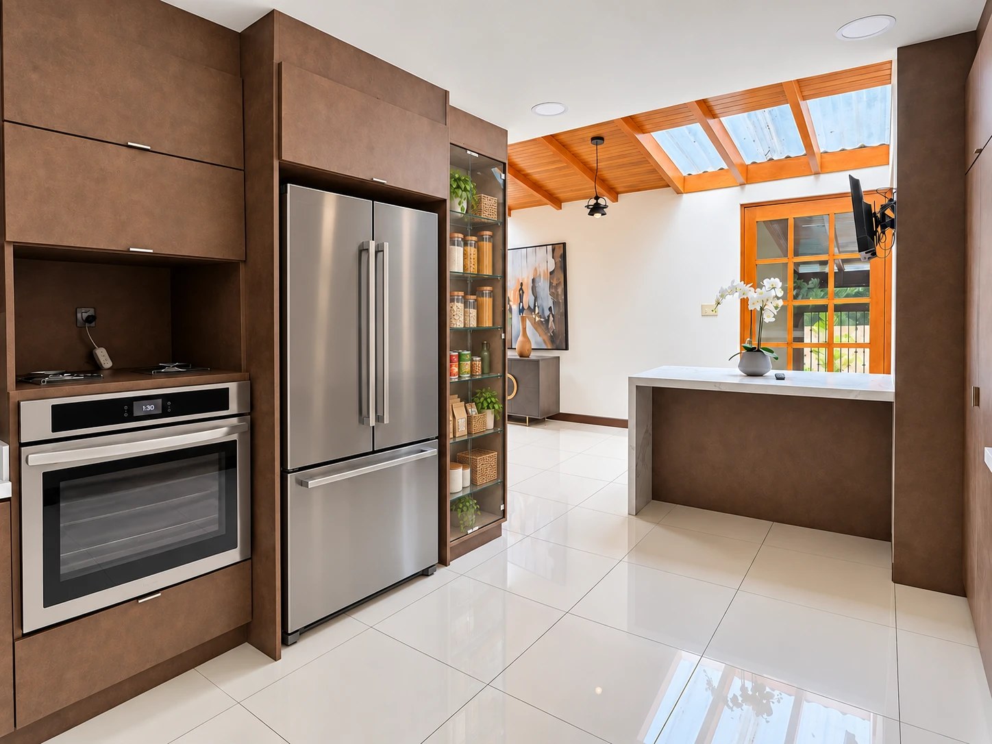 Kitchen with built-in oven, stainless refrigerator and breakfast bar under skylights