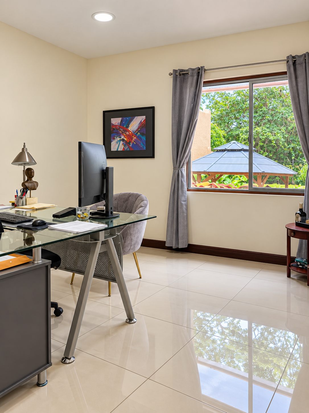 Office with a glass desk and computer by the window