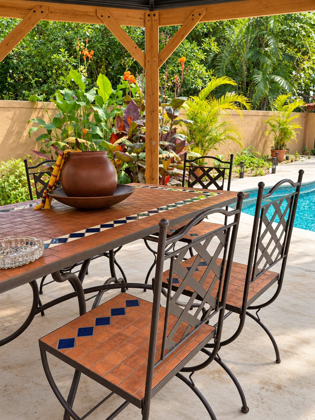 Tiled outdoor dining table under the pergola by the pool