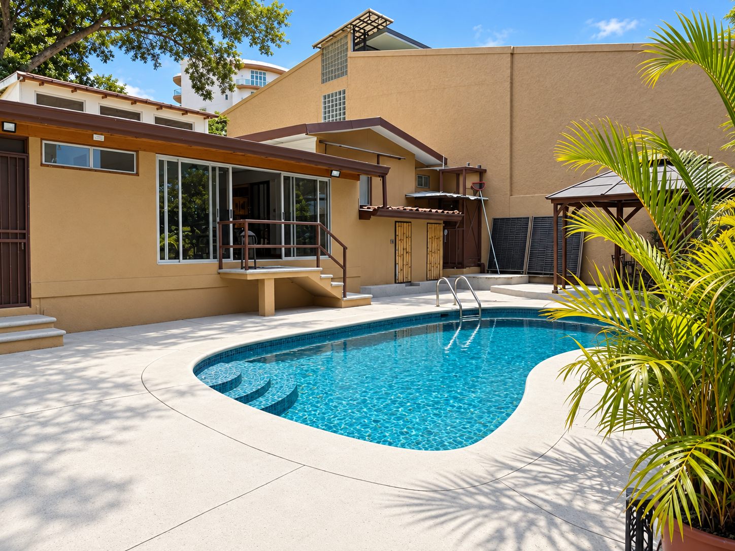 Kidney-shaped pool and sun deck behind the Escazú house