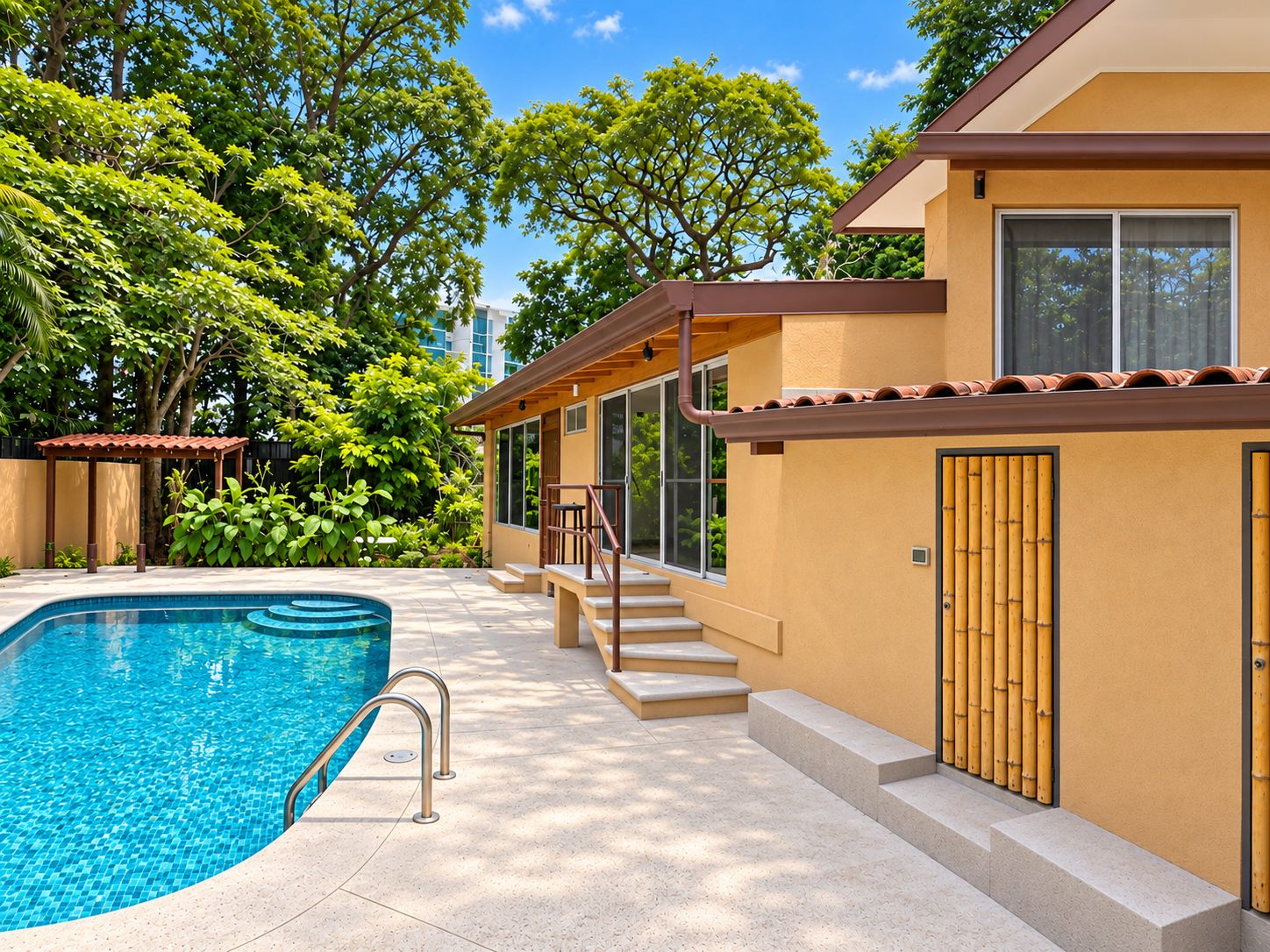 Pool deck with steps up to the house and tropical trees