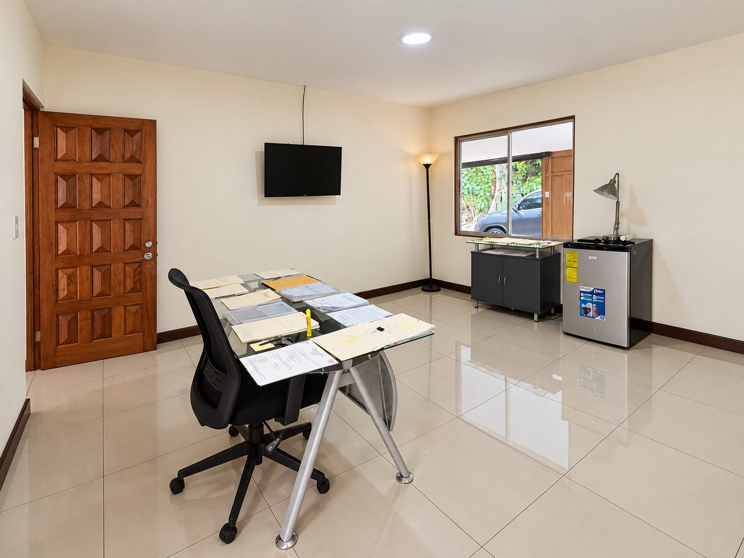 Private office with a desk and wall TV