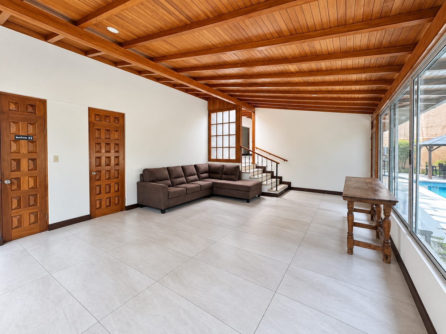 Large room with a wooden ceiling, sofa and stairs