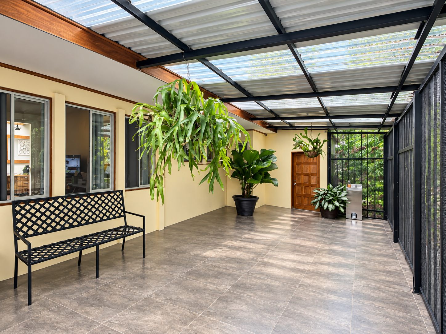 Glass-roofed sunroom with plants and a bench