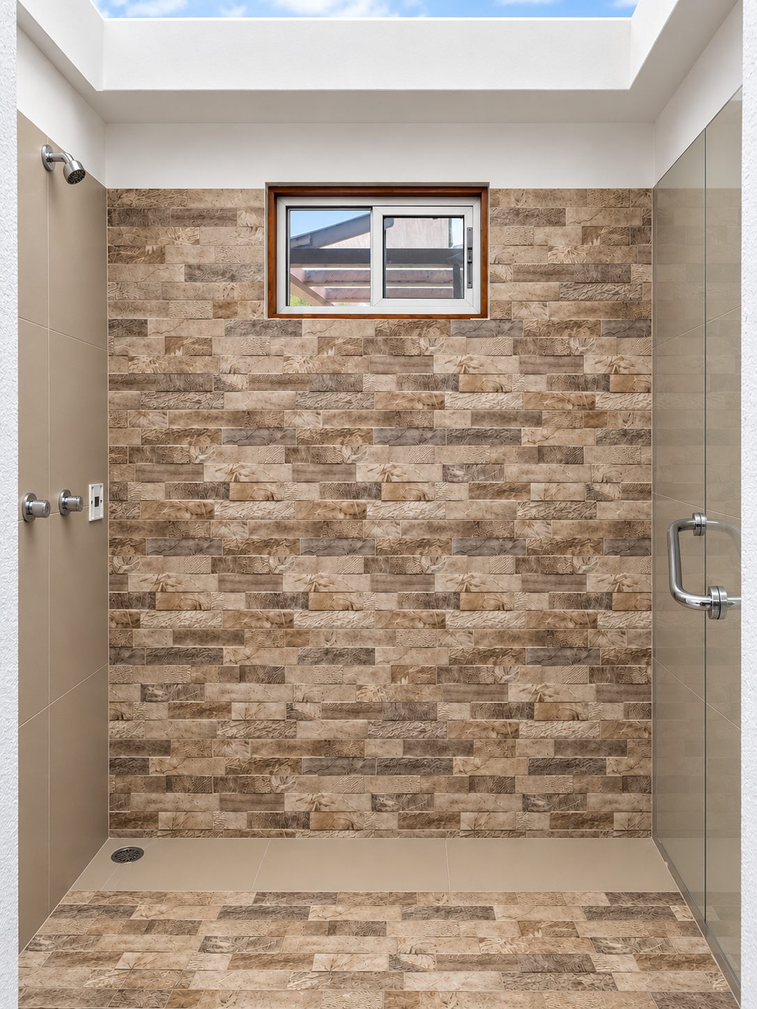 Walk-in shower with a stone tile wall and skylight