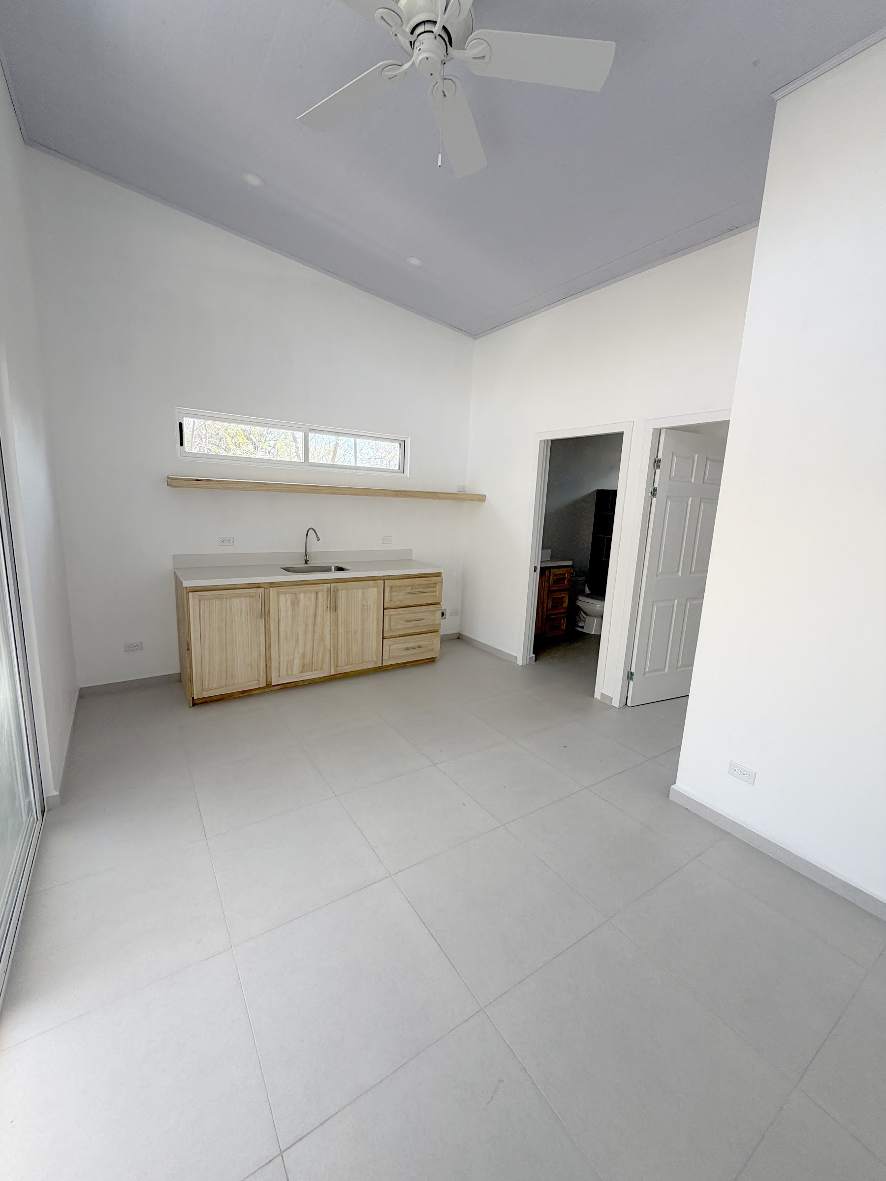 Kitchenette and living area with ceiling fan
