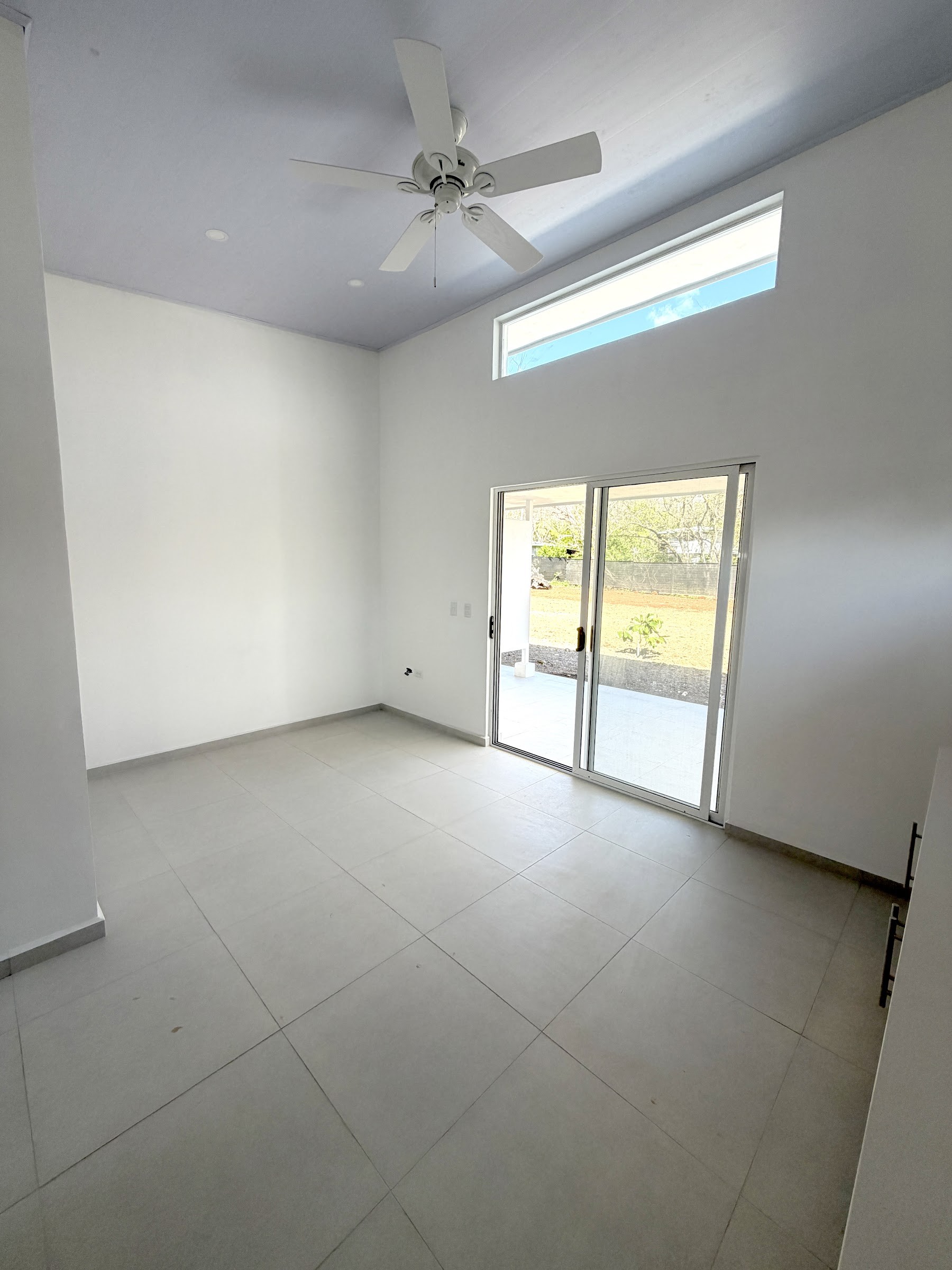 Bedroom with ceiling fan and sliding door