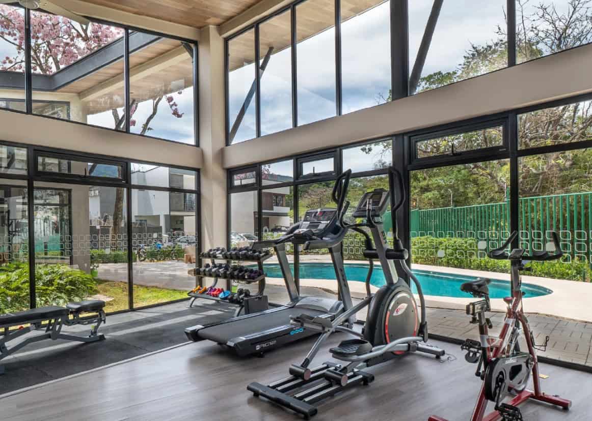 Clubhouse gym with glass walls looking onto the pool